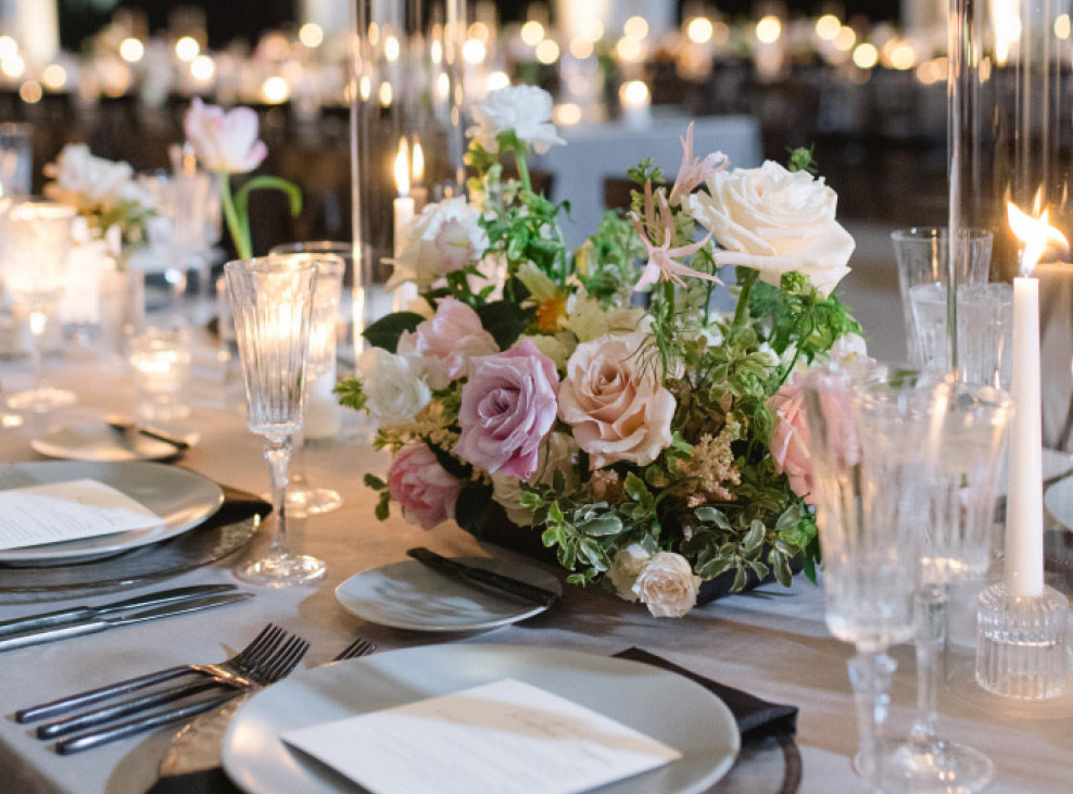 close up table decorations, flowers, glasses, plate, and silverware
