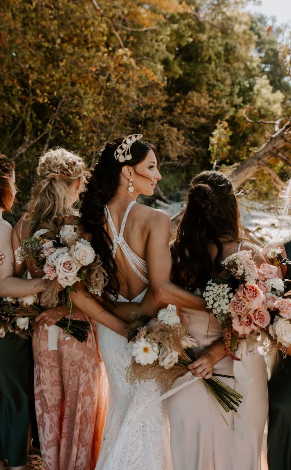 bride and bridesmaids with arms around each other