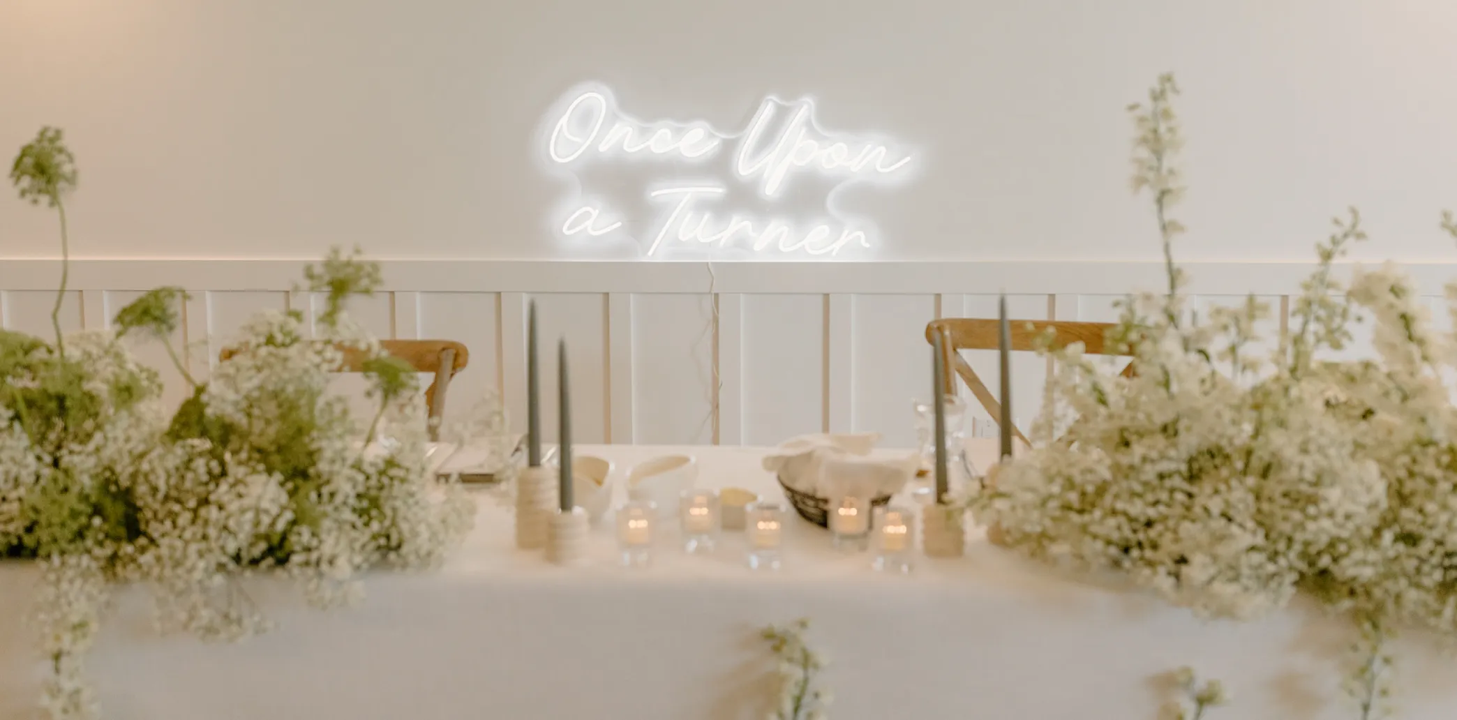 Neon sign above table at wedding that reads Once upon a turner