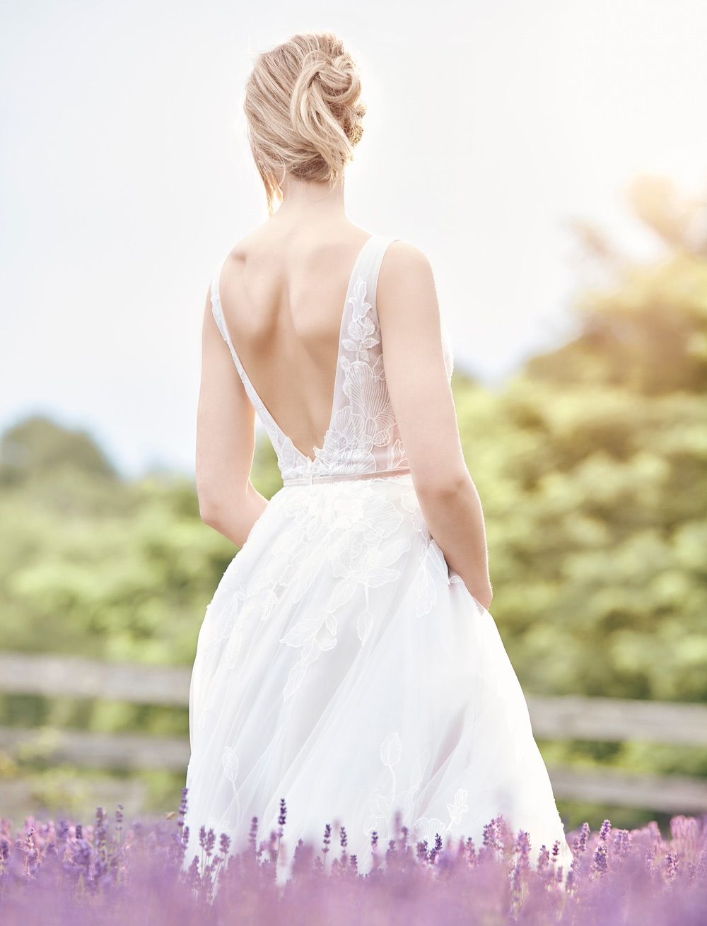 backside of blonde haired female model wearing the Beloved Sophie floral overlace gown