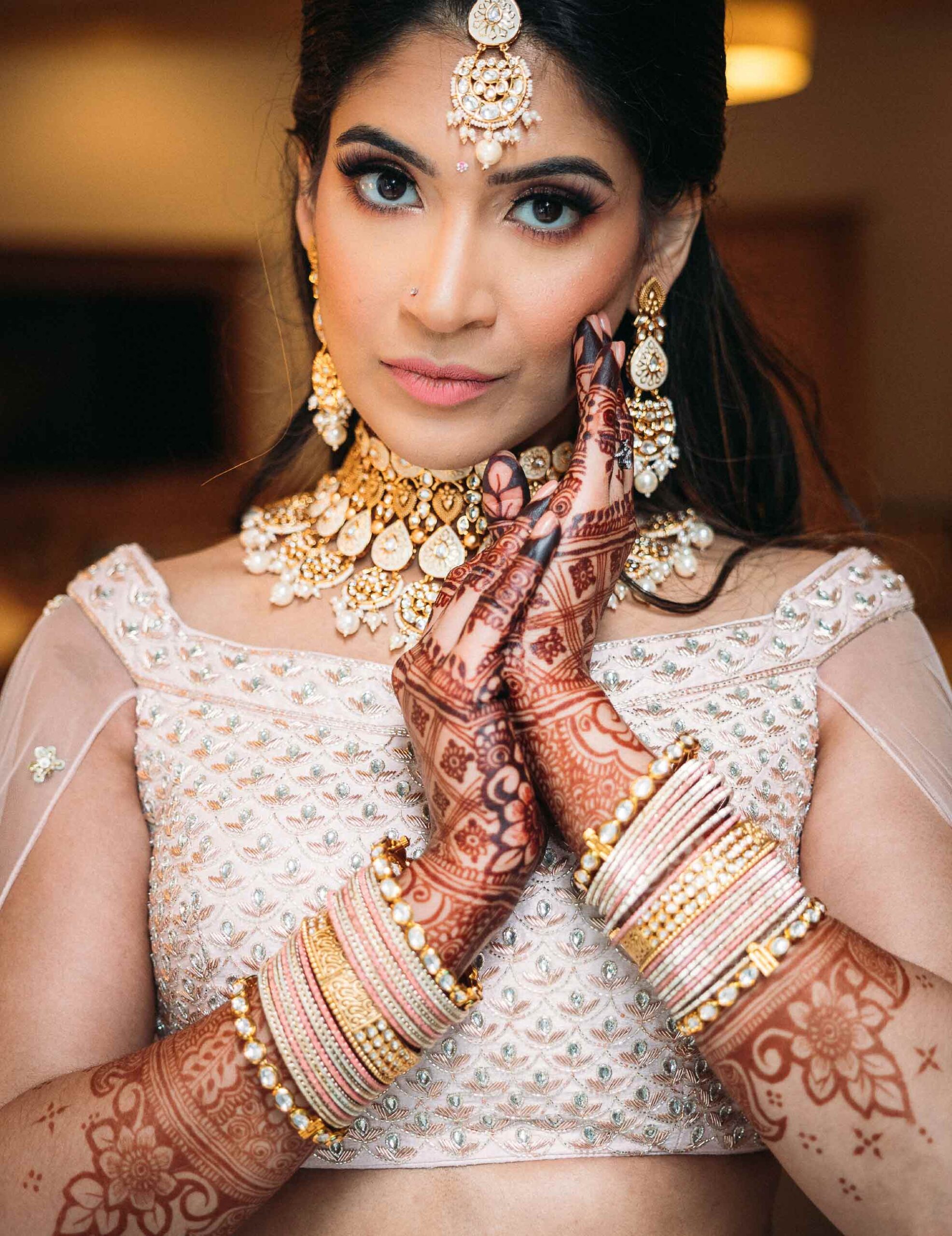 bride with hands covered in henna posing for portrait