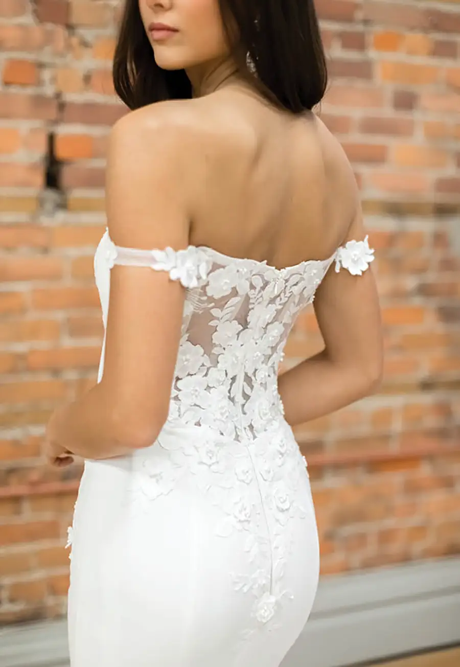 bride shows off back of wedding dress