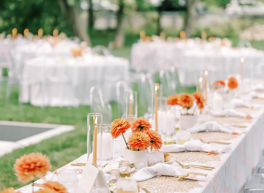 Outdoor table settings with orange flower center pieces