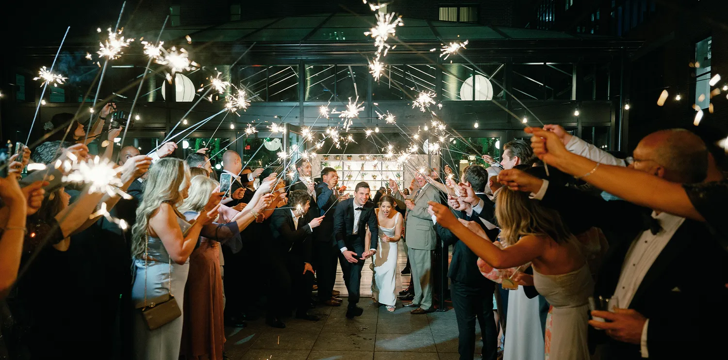 guests waving sparklers as Abbey and Joe walk down the aisle of the ceremony venue