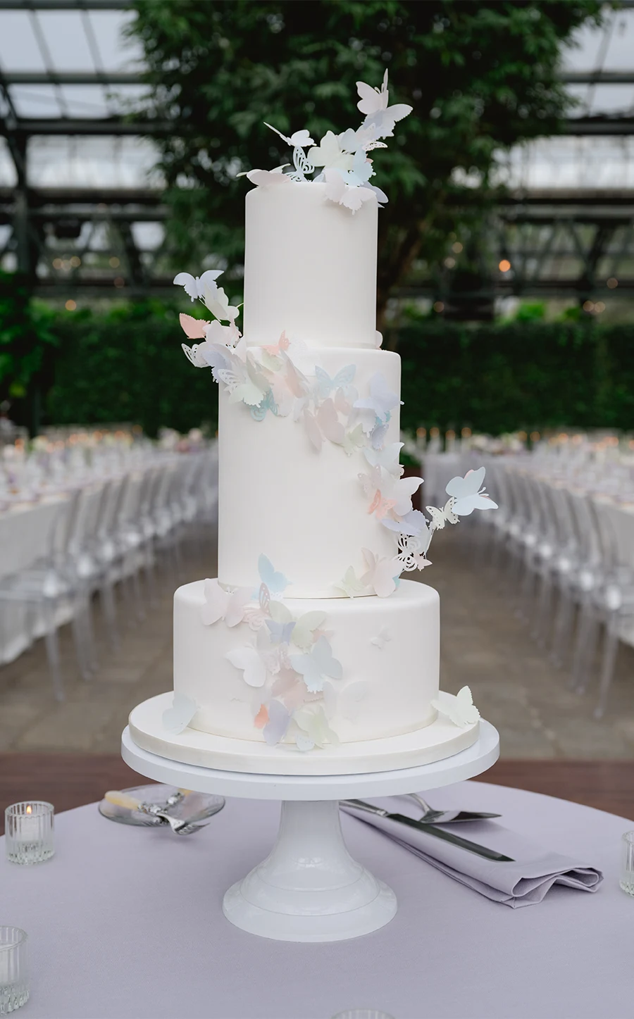 three-tier wedding cake with pastel butterfly decorations