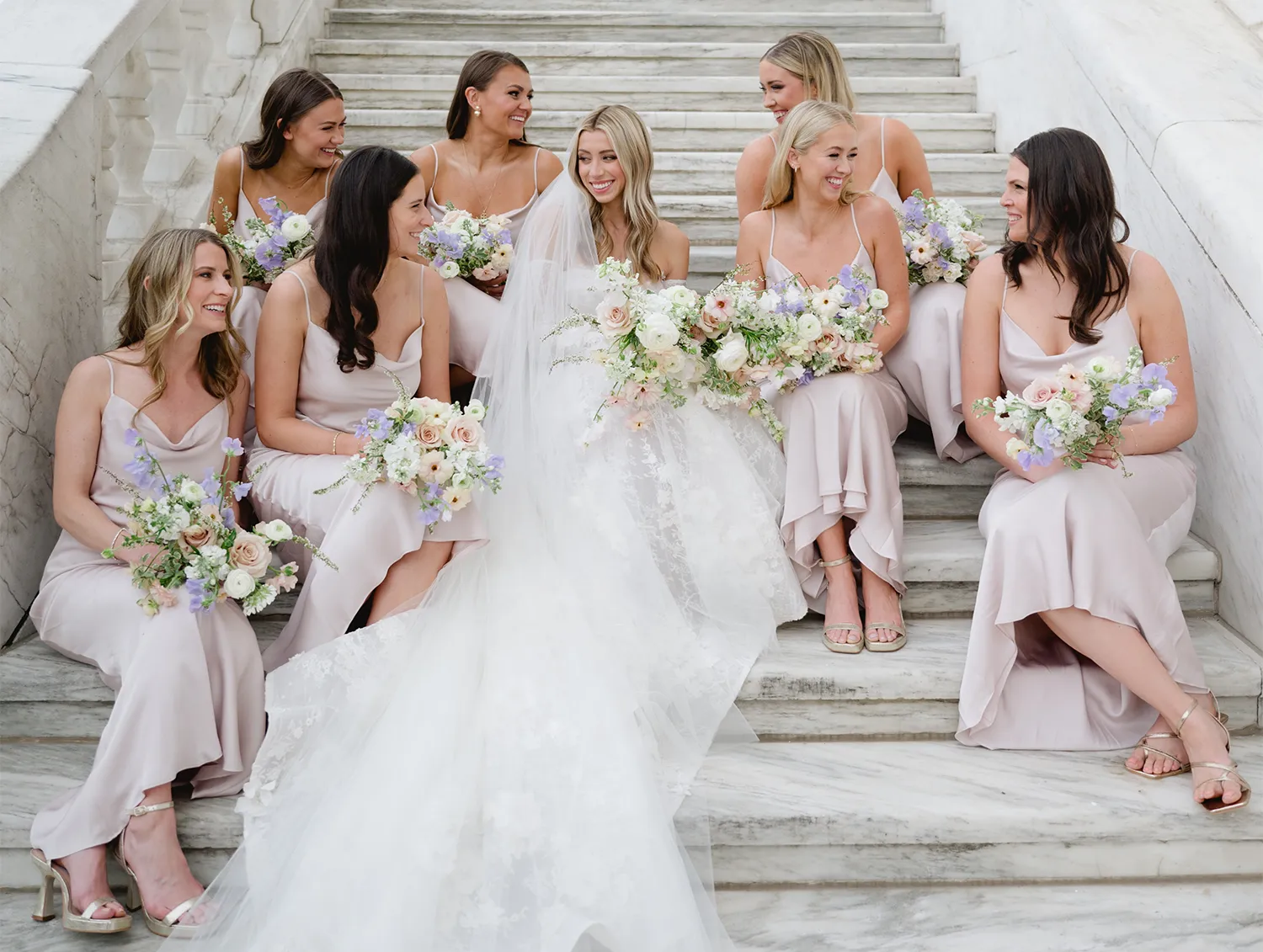 Allison sitting with her bridesmaids on marble steps