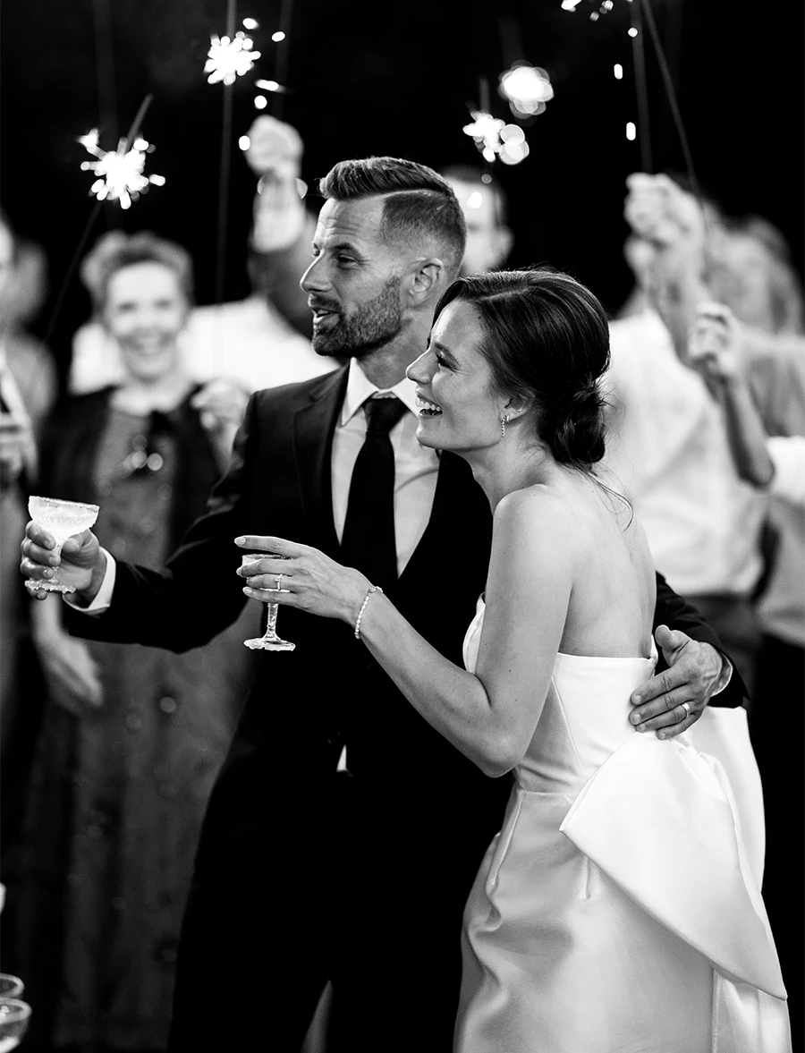 black and white photo of Codi and Tyler giving a toast at their wedding reception