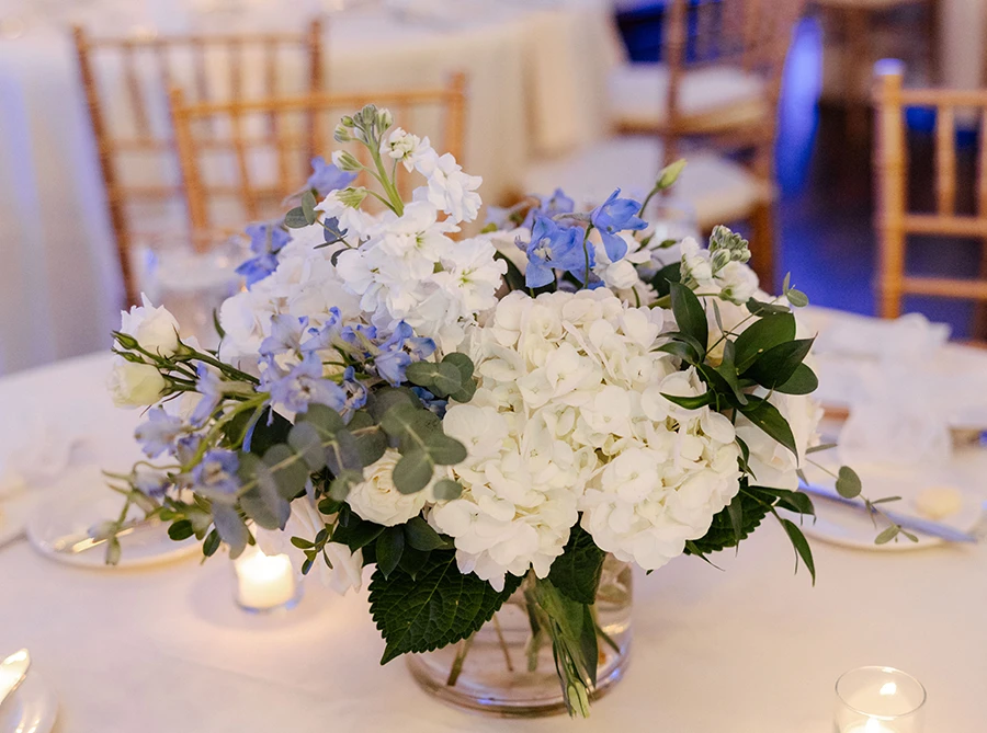 vase of blue and white flowers at the wedding reception