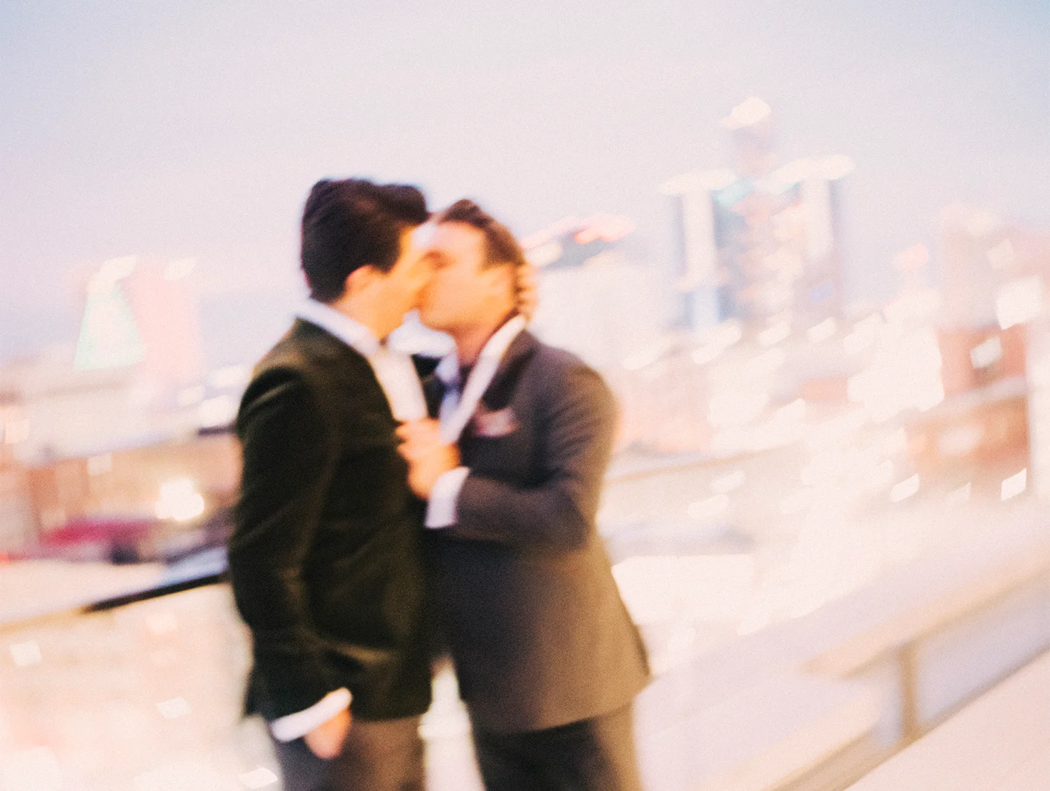 Lou and Vincent sharing a kiss with the city skyline in the background