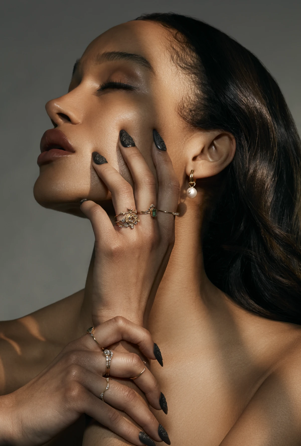 model with fingers resting on jaw while wearing Elaine B. Jewelry Looking Glass Ring, Pavé X Ring, and High Noon Ring