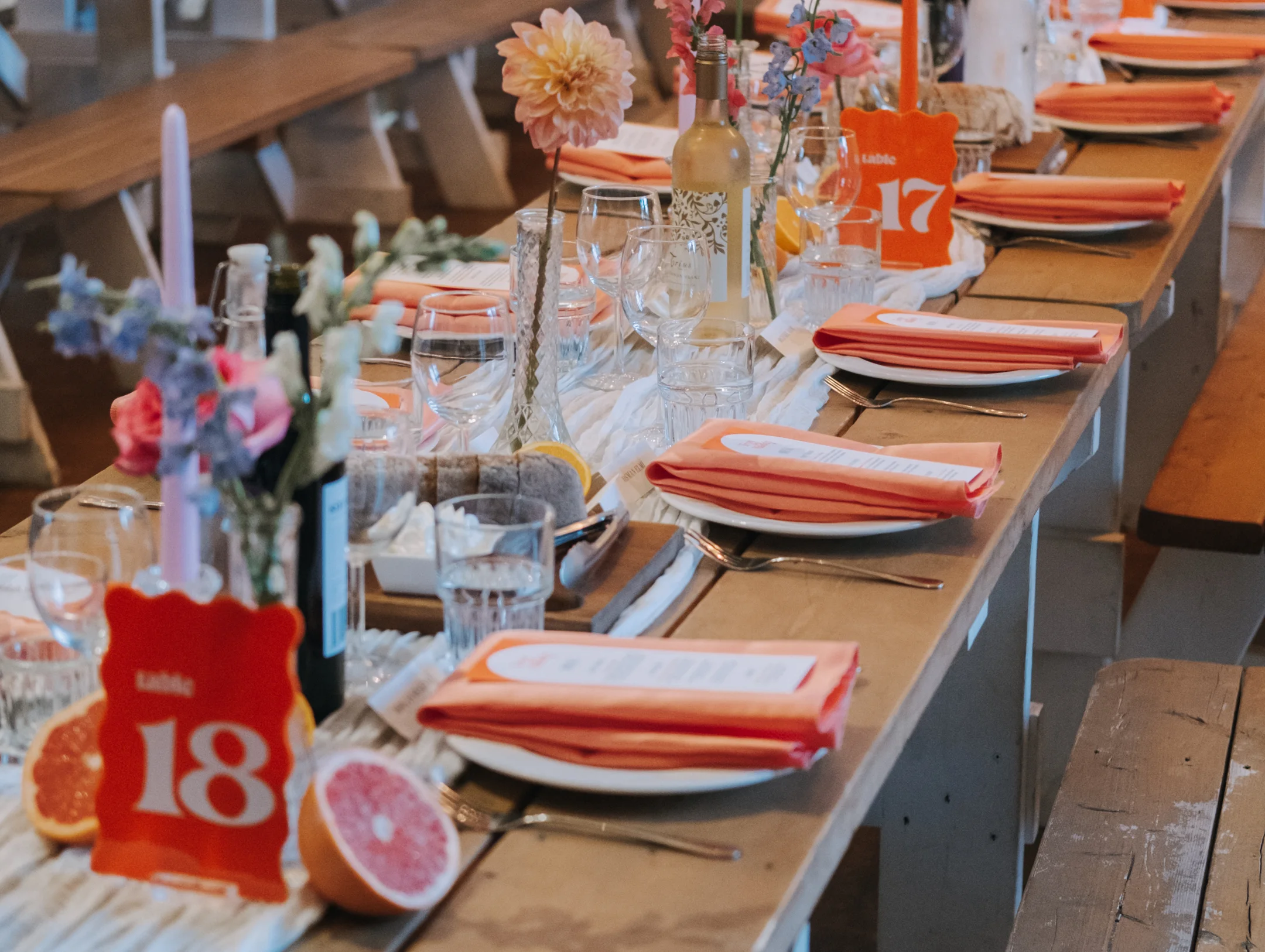 table setup of colorful flowers and orange napkins 
