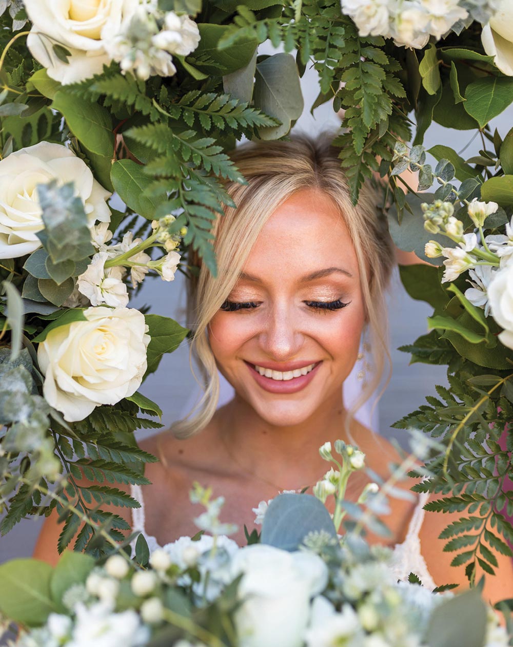 close up headshot of a bride with flowers surrounding the frame