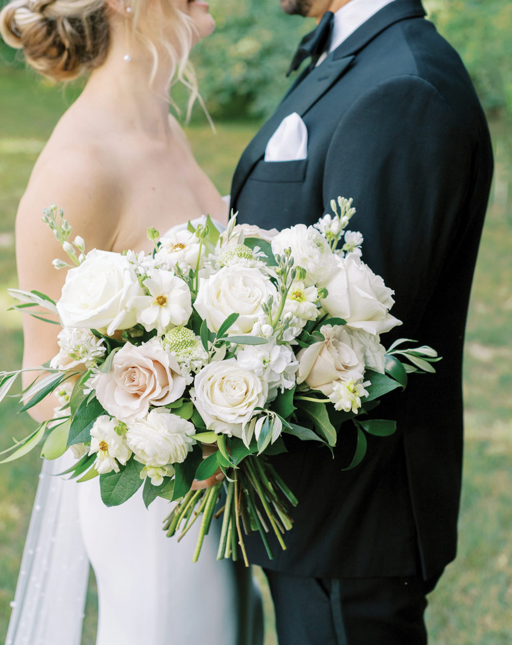 close up of bouquet from a bride while she's next to her groom