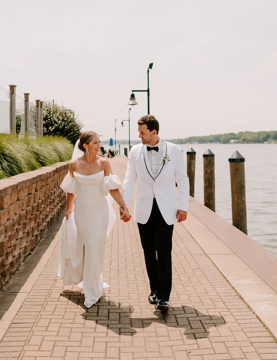 bride and groom walking down lakeside brick walkway